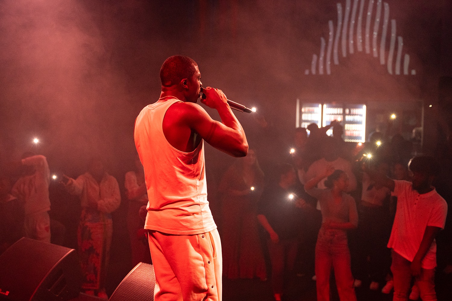 Bizzo performing to a crowd under warm lighting