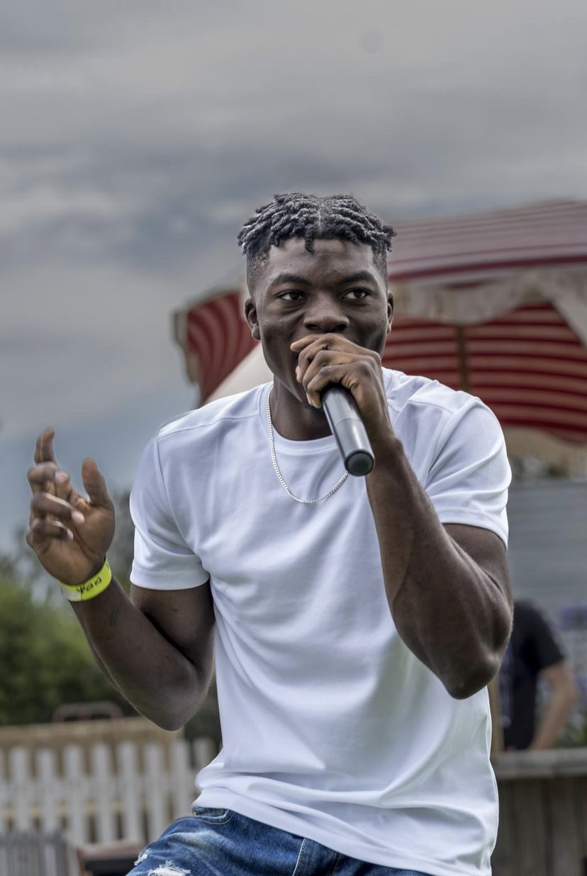 Bizzo performing live with raised microphone